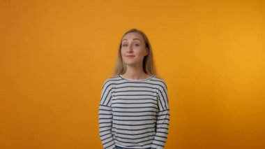 Genç bir kadın kameraya bakar ve el hareketleriyle onu takip etmek için arar..