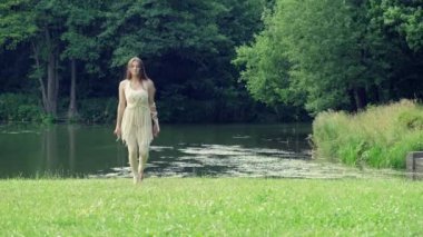 Uzun sarı saçlı genç bir kadın güzel dans eder. Kameraya bak..