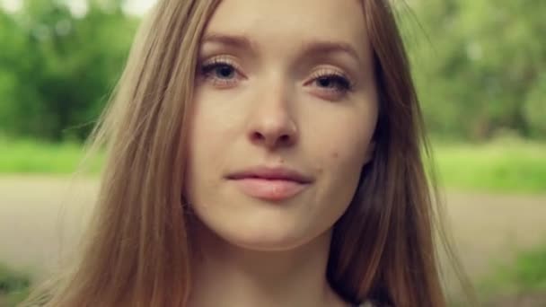 Il volto di una bella ragazza con trucco naturale, lunghi capelli biondi. Va avanti. — Video Stock