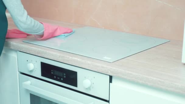 Ręka w rękawiczkach pilnie sprząta w kuchni, myje kuchenkę. — Wideo stockowe