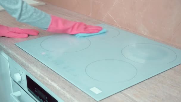 Samica w rękawiczkach myje powierzchnię pieca. Sprzątanie kuchni. — Wideo stockowe
