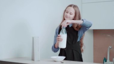 Sabahları bir kız kahvaltı hazırlar mısır gevreği ve sütü tabağa döker..