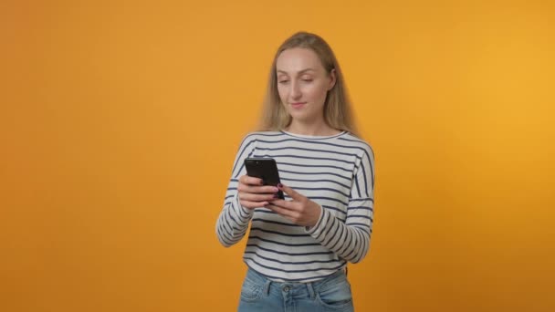 Uma jovem usa aplicativos para se comunicar on-line a partir de seu telefone. — Vídeo de Stock