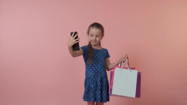 La chica tiene compras, regalos y se toma una selfie en la mano. — Vídeos de Stock