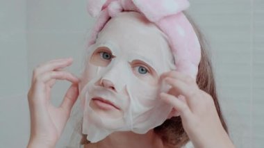 Yüzünde kumaş bir maske, kafasında yumuşak bir bandaj olan güzel bir kız..