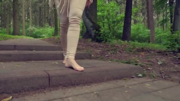 Босиком красивые женские ноги идут по каменной ступеньке. Вокруг леса. — стоковое видео