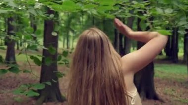 Arkadan, uzun saçlı, güzel, sarışın bir kızın manzarası. 4K video.