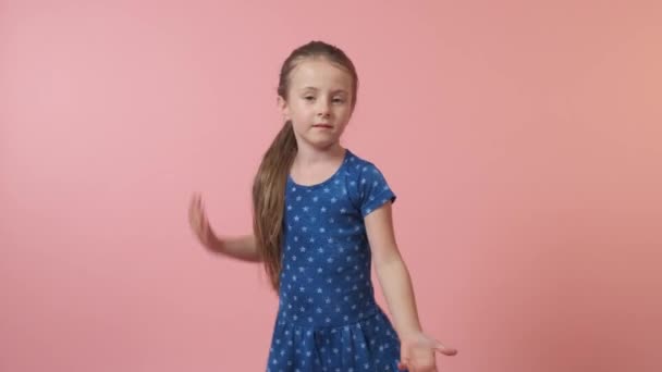 Una hermosa chica con el pelo largo está bailando en un vestido azul. — Vídeo de stock