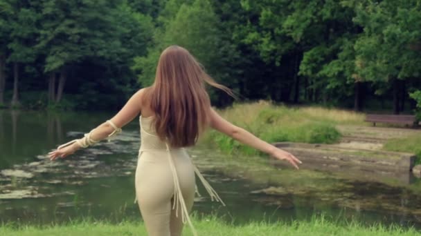 Gyönyörű fiatal nő örvénylik a háttérben a tó, fehér hosszú haj. — Stock videók