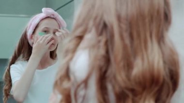 Sarı saçlı, göz bantlı güzel bir kız. Sabah rutini.