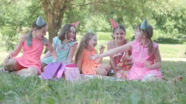 Picknick födelsedagskalas. Barn blåser i visselpipan på sin födelsedag. 4K-video. — Stockvideo