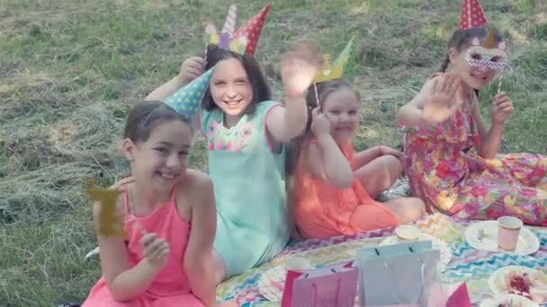 Děti v karnevalových maskách slaví narozeniny. Dívají se do rámu. — Stock video