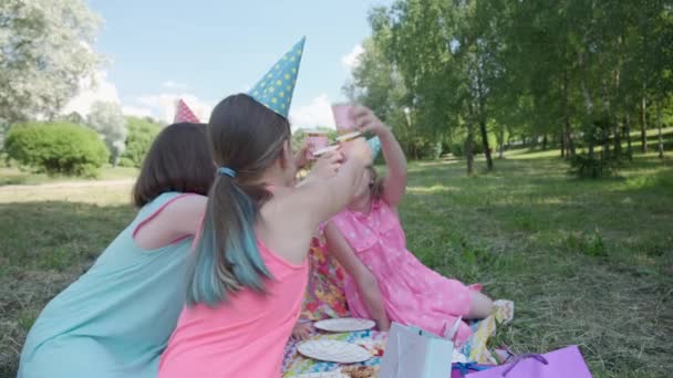 La vista trasera de las niñas en vestidos celebrando su cumpleaños y beber refrescos. — Vídeo de stock
