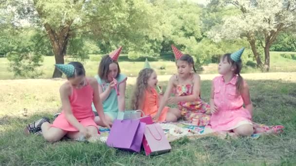 Feliz grupo de niños celebrando un cumpleaños en el jardín con un silbato. — Vídeos de Stock