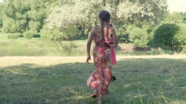 Yaz parkında bir kız köpük üflüyor ve arkadaşları baloncukların peşinden koşuyor..