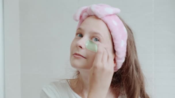 Cute blonde girl uses patches for the eyes, get rid of puffiness under the eyes. — Stock Video