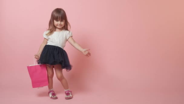 Aranyos kislány barna lány vásárlásokkal a kezében. — Stock videók