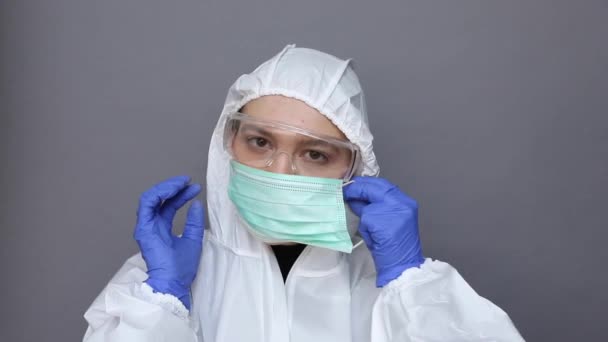 Arzt im Schutzanzug setzt Maske auf — Stockvideo