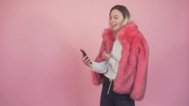 Güzel bir genç kız elinde bir telefon tutuyor ve selfie çekiyor..