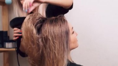 Profesyonel bir güzellik salonunda saçını kurula..