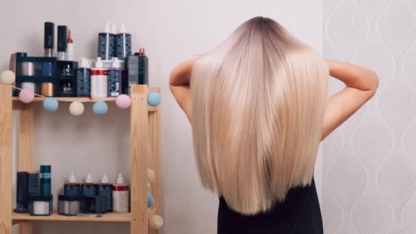 Achteraanzicht van het ontwikkelen van mooie glanzend blond lang haar. Gezond haar. — Stockvideo