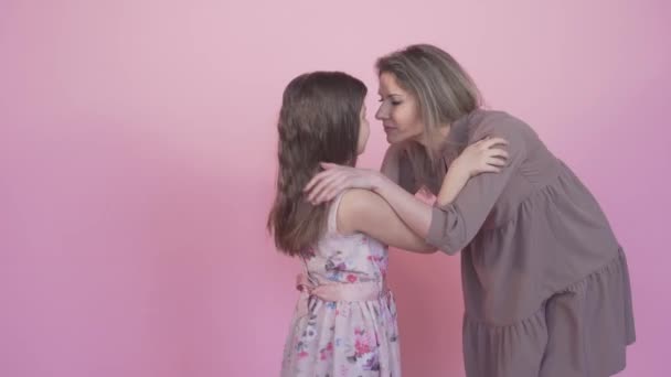 Mom plays with a beautiful little daughter play together. Pink background. — Stock Video