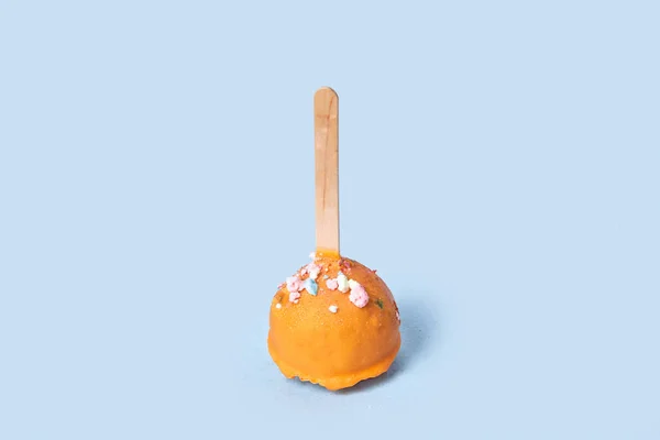 Postre de chocolate en esmalte naranja. Pastelería redonda sobre un palo de madera. — Foto de Stock