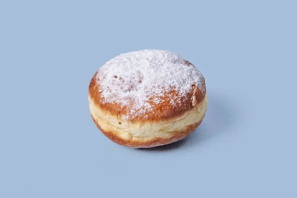 Close-up of a delicious sweet bagel with filling, sprinkled with powdered sugar.