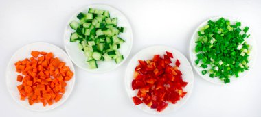 Beyaz arka planda ince dilimlenmiş sebze, salata malzemeleri, sebze karışımı, sağlıklı yiyecek ve organik vejetaryen ürünleri içeren tabaklar.