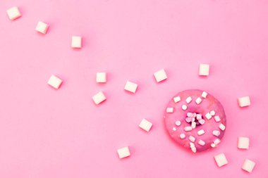 Şekerli ve kremalı tatlı çörek pembe arka planda mesaj için yer var..