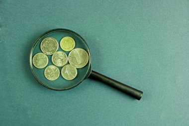 Bozuk paralar ve büyüteç. Büyümek ve para biriktirmek. Ekonomi, bütçe ve finans kavramı