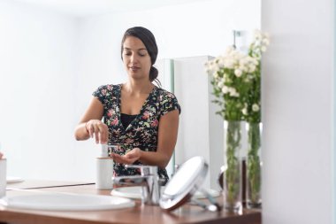 Banyoda ellerini sabunla yıkayan kadın.