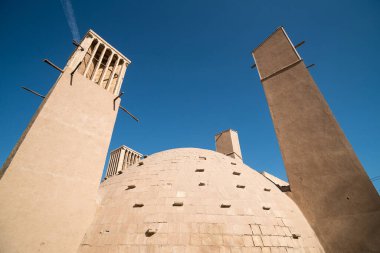 İran Yazd 'daki rüzgar kuleleri ve kubbe şeklindeki buz odası binası.