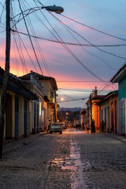 24 Ağustos 2019, gün batımında kaldırım taşı caddesinde eski bir Amerikan arabasıyla sokak manzarası. Trinidad, Küba