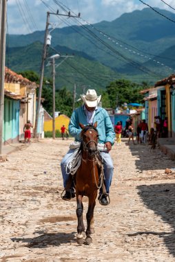 24 Ağustos 2019: Trinidad 'ın renkli sokaklarında ata binen adam. Trinidad, Küba