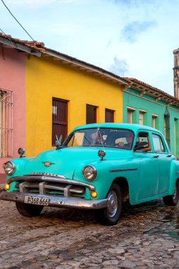 24 Ağustos 2019 'da, kaldırım taşları üzerinde eski bir Amerikan arabasıyla sokak manzarası. Trinidad, Küba