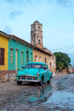 24 Ağustos 2019 'da, kaldırım taşları üzerinde eski bir Amerikan arabasıyla sokak manzarası. Trinidad, Küba