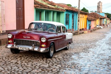24 Ağustos 2019 'da, kaldırım taşları üzerinde eski bir Amerikan arabasıyla sokak manzarası. Trinidad, Küba