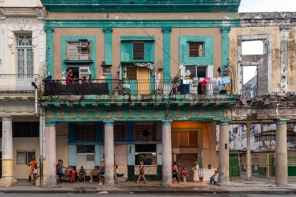 4 Eylül 2019: Bir iskan binasının yıpranmış cephesinin önündeki insanlar. Havana, Küba