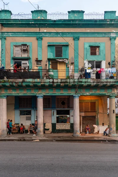4 Eylül 2019: Bir iskan binasının yıpranmış cephesinin önündeki insanlar. Havana, Küba