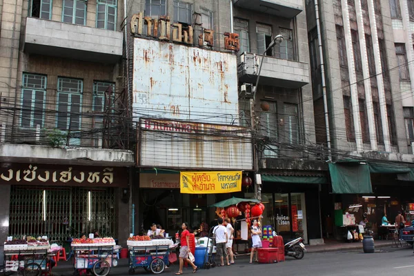 Bangkok Çin Mahallesi. Büyük eski bir ev. Arabalar ile meyve ticareti. Kırmızı fenerler