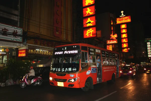 Chinatown Bangkok 'ta. Gece. Trafik. Sarı hiyeroglifleri. Kırmızı otobüs