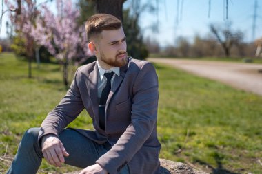 Ağaç uzatan, gözleri kapalı, sakallı bir gencin portresi. Açık havada. Yaratıcı sanatsal tonlamada. İş konsepti. 25 yaşındaki genç bir adamın kafasından çıkan bahar fotoğrafı ağacı, iş konsepti. Düşüncelerin doğuşu,