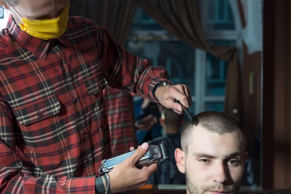 戴着防护面具的考罗纳维尔斯理发师在理发店割伤了一个年轻人的头发 科维德19岁 理发师 理发店理发师 为一个27岁的男人理发 他的头发短 头发蓬松而引人注目 — 图库照片