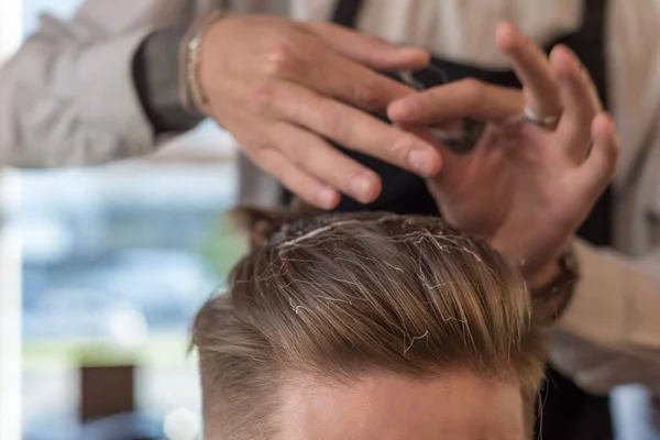Närbild av frisör frisör master hand distribuerar vax trådar för manliga kunder hår. I frisersalongen. Professionell hårvård, skydd av manligt hår med vax. — Stockfoto