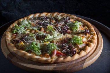 İnce dilimlenmiş pepperoni, Amerikan usulü pizzacılarda popüler bir pizza çeşididir. Bir tepside yakın plan pizza, sebze ve etle birlikte, kırsal bir tarzda. Olağandışı bir açı. Salata, sebzeli pizza, et yemeği. Dost canlısı pizza. Pizzanın dokusu. Yiyecekler. Ba