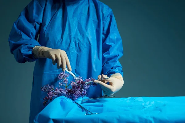 medical surgical concept. The doctor in gloves with his hands using a scalpel, scissors operates on spring flowers. Medicine, surgery, surgical flowers, yellow wildflower, beauty and health, the concept of plastic surgery, aesthetic medicine, natural