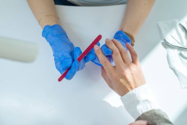 Otuz yaşındaki bir adam için erkek manikürüne yakın çekim. Erkek tırnaklarının güzelliği, erkek tırnaklarıyla ilgilenmek. Tırnakların sağlığı ve güzelliği, bir filin maniküründeki tırnak testeresi..