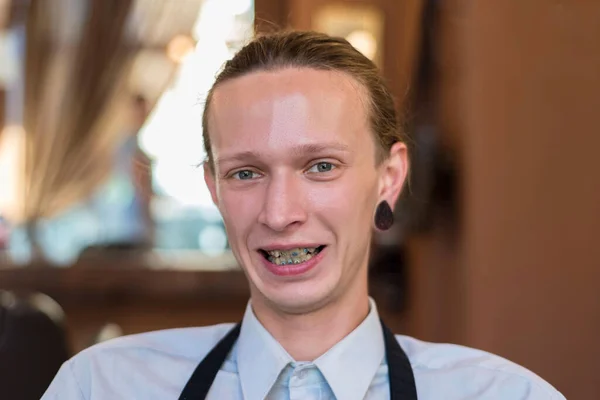 Portrait of a businessman wearing braces and smiling confidently Portrait of a twenty five year old guy with braces on his teeth, smiling. Wrong bite in a young smiling guy. Dental pathology, correction of malocclusion in young people. Dental abnorma