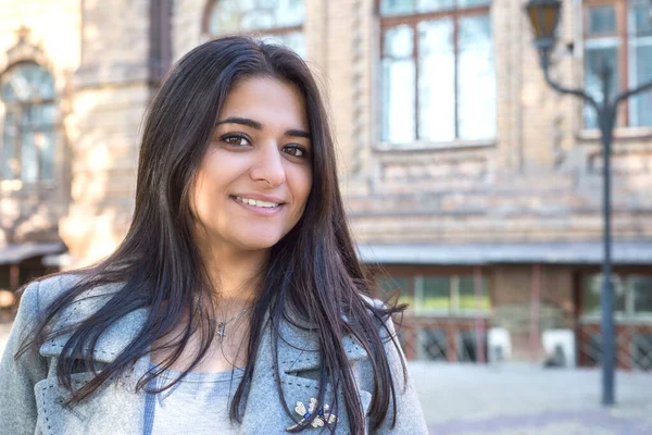Gülümseyen güzel bir Hintli kızın portresi. Eski bir binanın arka planına karşı. Kız, kameraya bakıyor. Gülümseyen Hintli kadın. Sonbahar zamanı kızım..